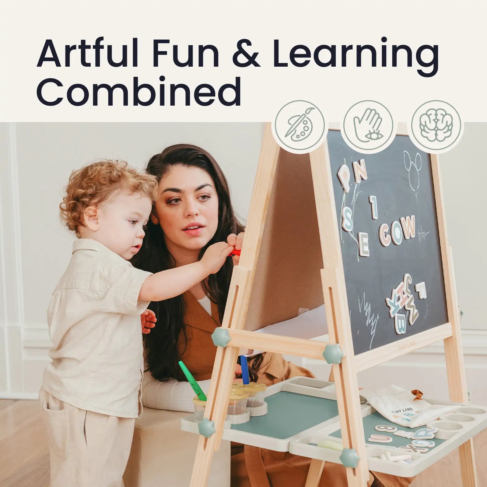 A woman and child play at a Tiny Land® Magnitales Easel for Kids - Green, using colorful magnets and art supplies. Text above: Artful Fun & Learning Combined, with three icons depicting creativity and learning. Brand: Tiny Land.|green