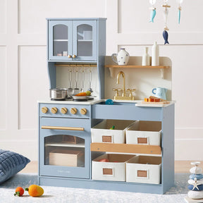 The Tiny Land® Serenity Wooden Play Kitchen for Kids in blue & green includes a stove, oven, sink, pots, utensils, toy kettle, shelves, and four fabric bins—ideal for imaginative play. Soft toys and décor can be placed nearby.|blue