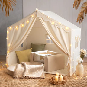 The Tiny Land® Kids Tent – Large Cozy Tent with Star Lights by Tiny Land features soft pillows, a blanket, and a small sofa on a woven rug, creating a warm, inviting atmosphere perfect for kids to play and relax.|fabric