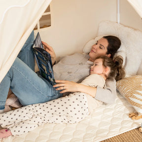 A woman and a young girl relax inside the Tiny Land® Kids Tent – Large Cozy Tent with Star Lights, reading together. The cozy hideaway from Tiny Land offers comfort and warmth, perfect for special bonding moments.|fabric