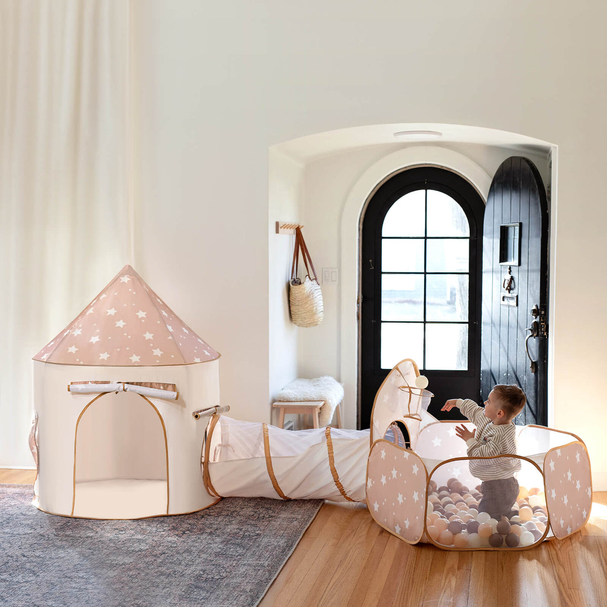A toddler enjoys the Tiny Land® Adventure 3-in-1 Play Tunnel & Ocean Ball Set, featuring a star-patterned ball pit linked to a matching tunnel and tent, all by Tiny Land in a cozy room with playful decor.|brown