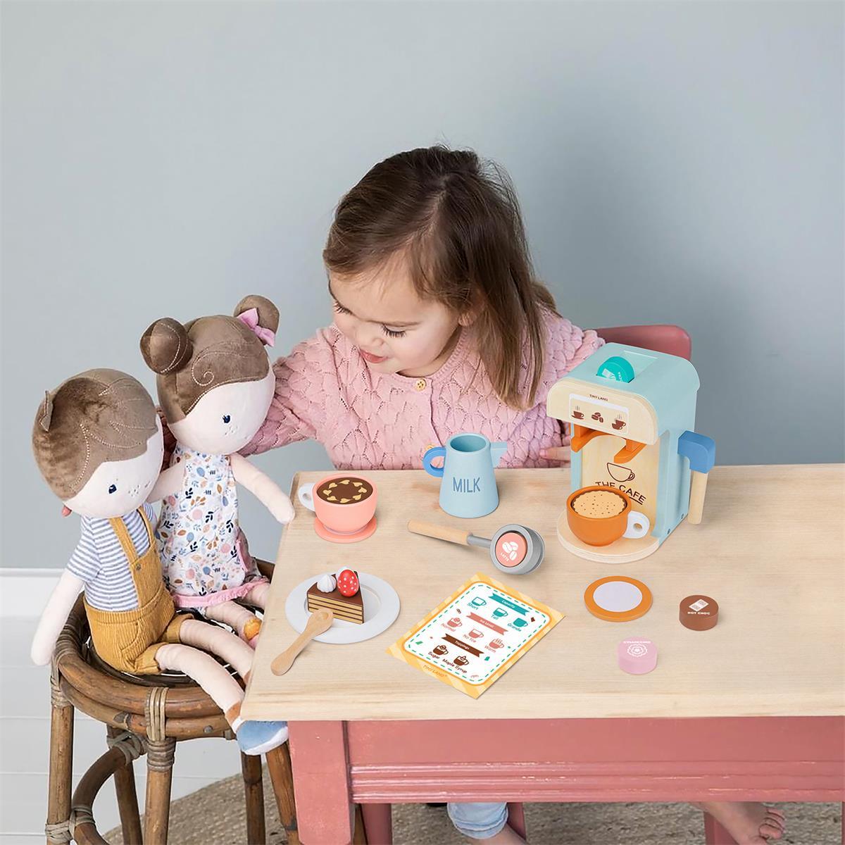 A young girl enjoys pretend play, serving drinks to two cloth dolls with the Tiny Land® Smart Storage Kitchen Cafe Set by Tiny Land, complete with cups, a milk carton, and play food for a delightful cafe scene.