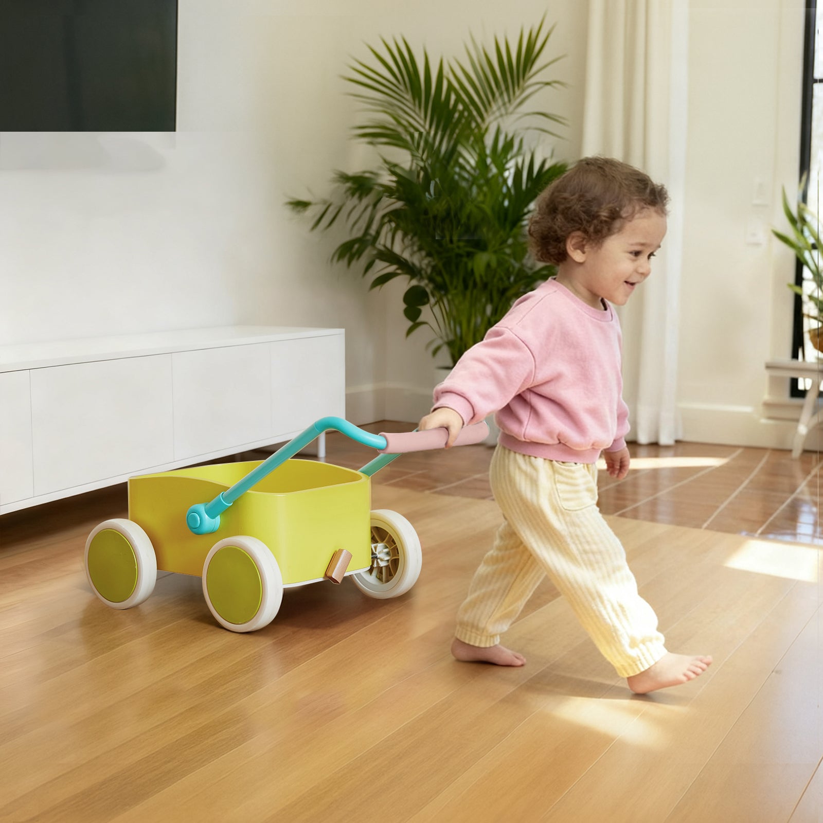 A young child pulls the Tiny Land® 3-in-1 Wooden Baby Walker Wagon - Spring Color across a bright, modern living room with wooden floors and green plants.