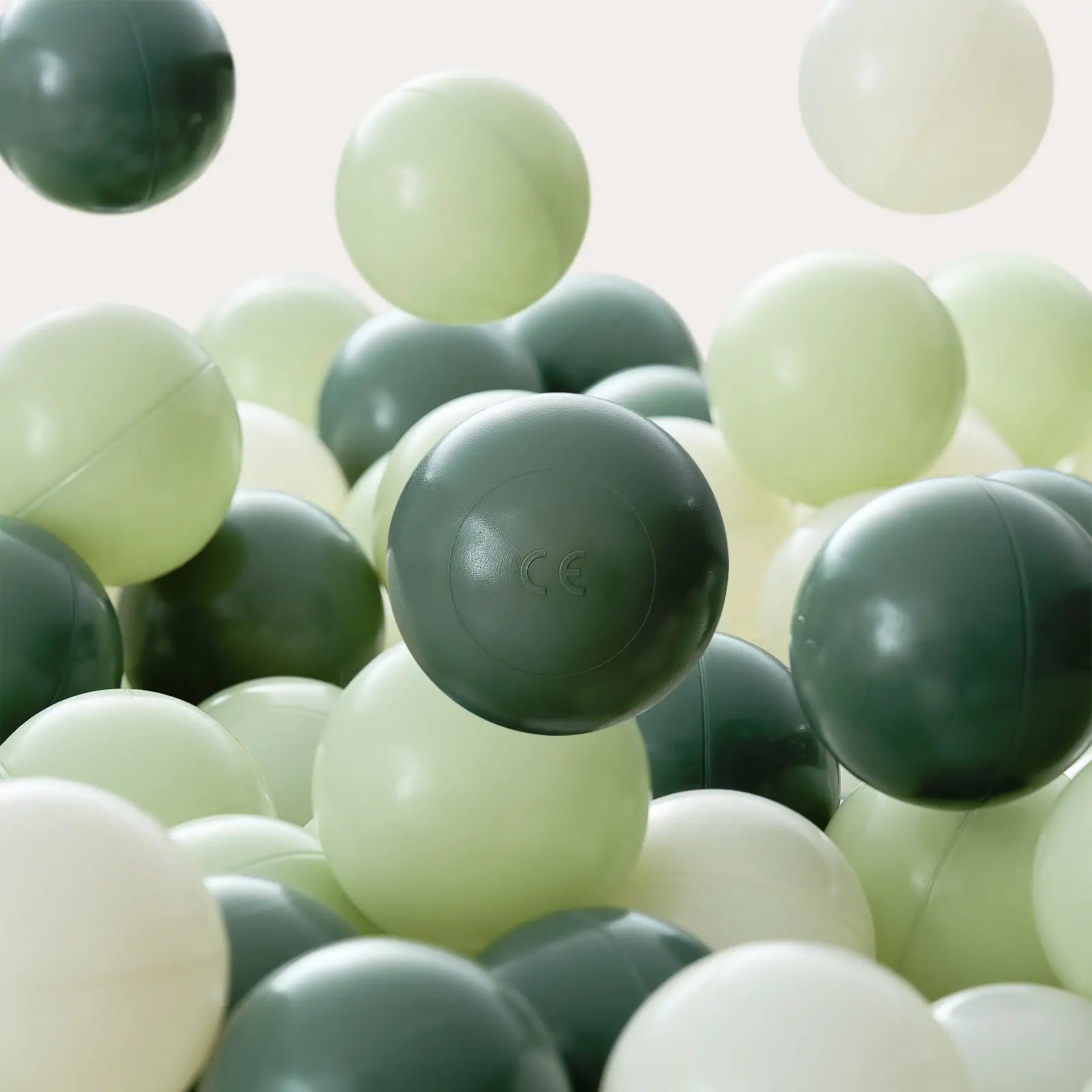 Close-up of Tiny Land® Ocean Balls in dark green, light green, and off-white—ideal for filling your Tiny Land Adventure 3-in-1 Play Tunnel. Set shown on a plain, light background.