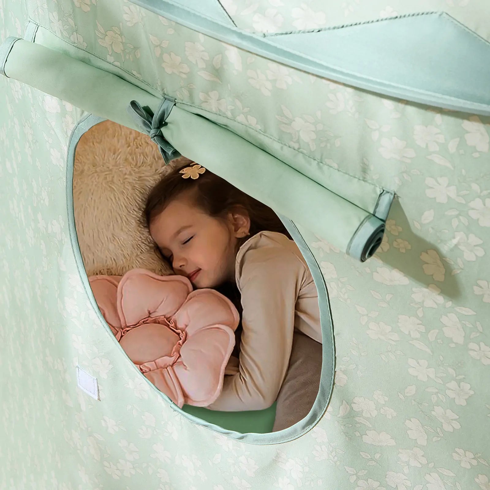 A young girl sleeps peacefully inside the Tiny Land® Tiny Sprout Castle Tent, holding a pink flower-shaped pillow and resting her head on a beige cushion.|Green