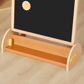The Tiny Land® Double-Sided Arched Magnet Chalkboard & Art Kit by Tiny Land features a wooden frame with both a chalkboard and magnetic surface, a playful yellow sun-shaped magnet, and a convenient tray at the bottom. Placed on a light wooden floor, this art easel is an ideal addition to any kids’ art accessory kit.