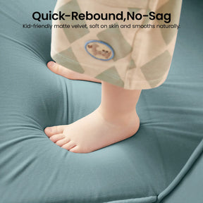 A child’s bare feet stand on the soft, teal surface of the Tiny Land® GentleSnug Kids Sofa Chair, demonstrating its quick-rebound, no-sag design—perfect for little ones. The child is wearing patterned pants, and the chair’s plush, smooth fabric highlights its quality craftsmanship from Tiny Land.|Blue