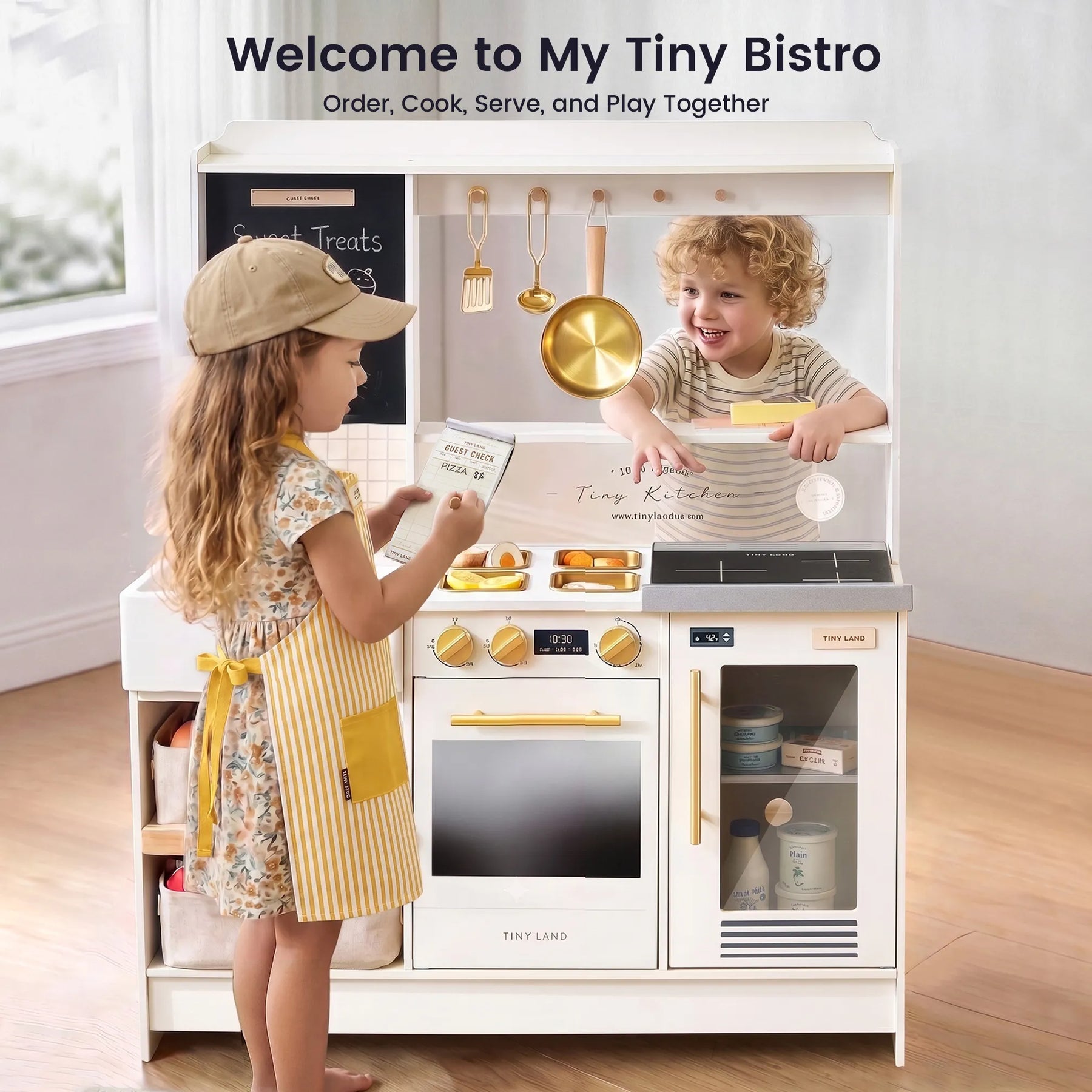 Two young children engage in imaginative play with the Tiny Land® BistroSwitch Play Kitchen by Tiny Land—one child, wearing a cap and apron, takes an order while the other sits behind the counter, smiling as they “cook.”.|Cream