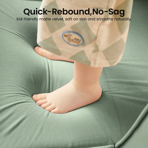 A child’s bare feet standing on a soft, green, cushioned surface—just like the Tiny Land® GentleSnug Kids Sofa Chair. Text above reads: Quick-Rebound, No-Sag. Kid-friendly matte velvet by Tiny Land—gentle on skin and naturally smooth.|Light Green