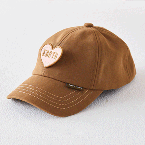 A brown baseball cap with white stitching and a heart patch reading EARTH. Partially showing the Tiny Land label, it’s a fun accessory for playful days and pairs perfectly with the Tiny Land® BistroSwitch Play Kitchen.|White