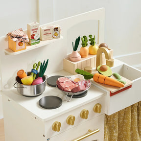 A brightly lit, child-friendly toy kitchen set featuring the Tiny Land® Organic Fruit & Veggie Pack by Tiny Land Play Food, with a sink, stove, countertop, play pots and pans, wooden vegetables, meat items, and food boxes for toddlers.