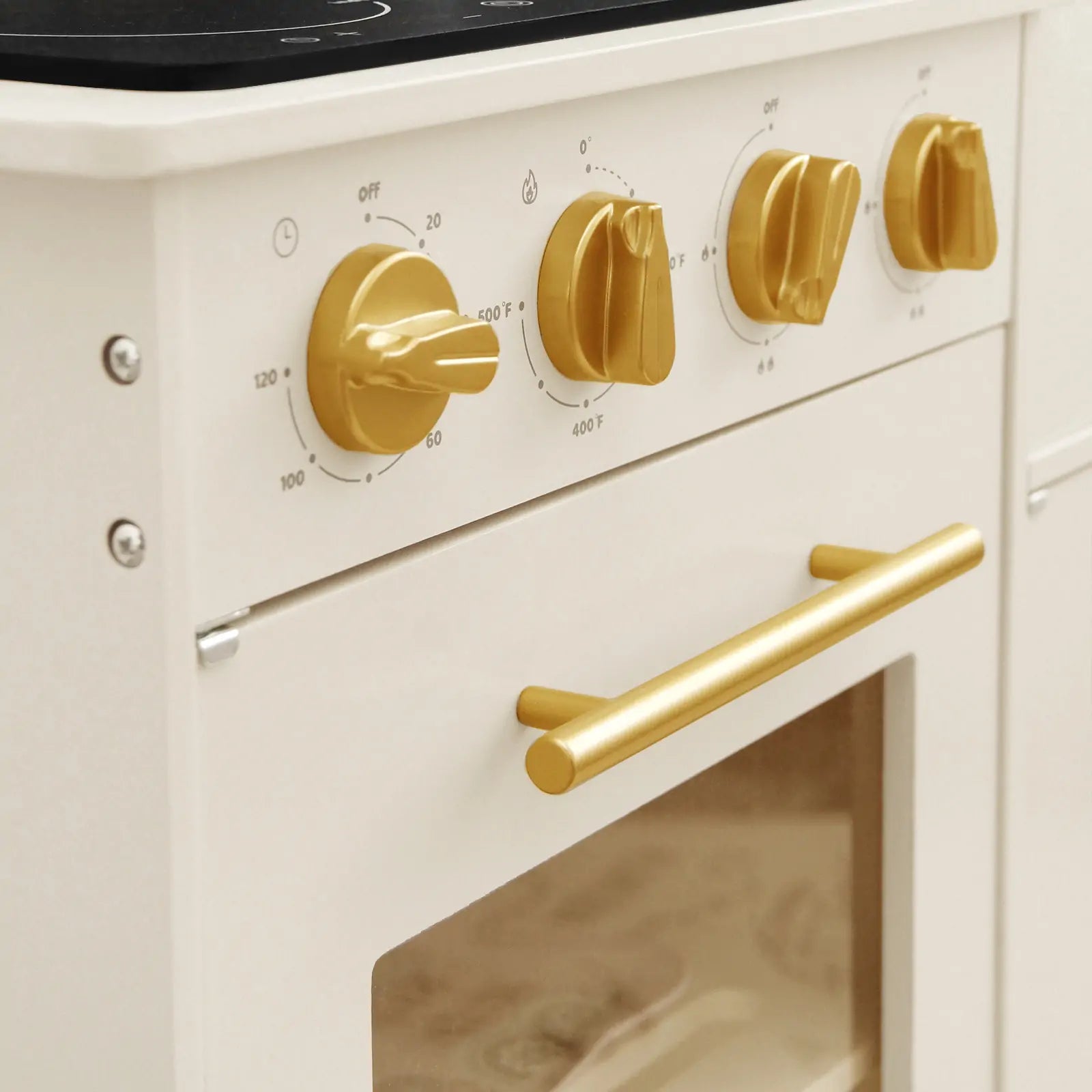 Close-up of the Tiny Land® Iconic Wooden Play Kitchen in cream, featuring gold knobs with marked settings and a windowed oven door for realistic play. A luxurious pretend cooking set for kids by Tiny Land.