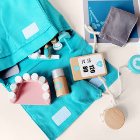 The Tiny Land® Doctor Kit for Kids by Tiny Land features a turquoise bag, pretend dental tools, model teeth, clipboard, pill bottle, and medical accessories—perfect for childrens imaginative play.